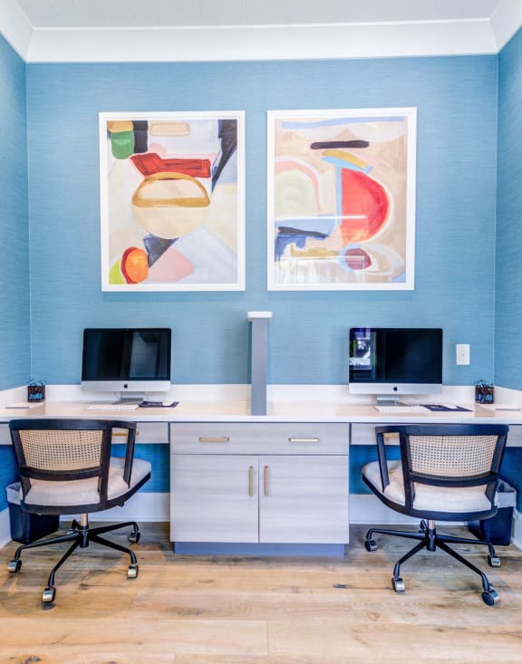 two desks with two monitors and two chairs in a room with blue walls at Residences at 393 North Apartments, Santa Rosa Beach, Florida