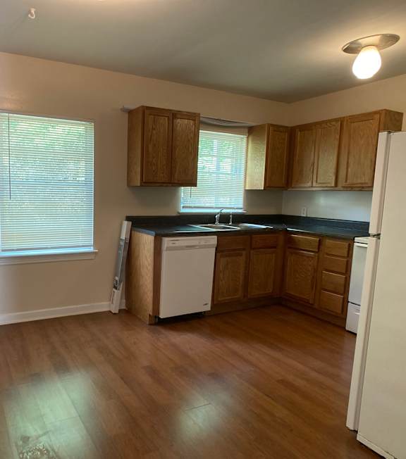 an empty kitchen with wooden floors and wooden cabinets