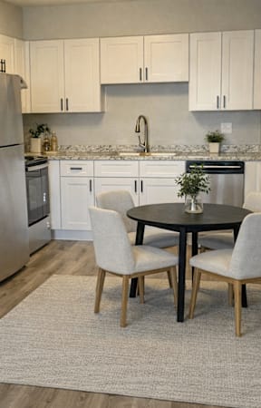 A kitchen with a table and chairs in the middle of the room.