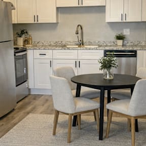 A kitchen with a table and chairs in the middle of the room.