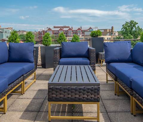 A patio with blue couches and a table.