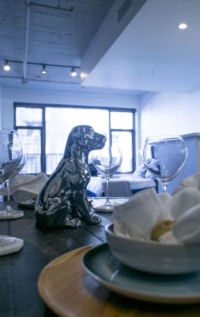 a dining room table with plates and glasses and a statue of a dog at Garment Lofts, California, 90014