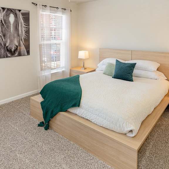 A bedroom with a bed, nightstands, and a ceiling fan.