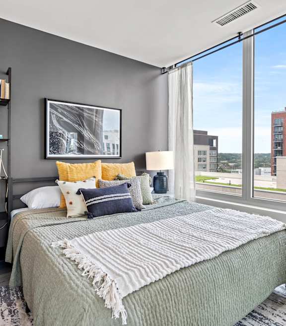 A bedroom with a large bed and a view of the city.