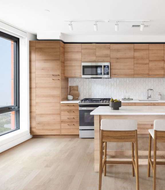 a kitchen with wooden cabinets and a white counter top and a window at The Grace and Reva, Arlington, 22202