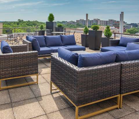 A patio with blue cushions and wicker furniture.