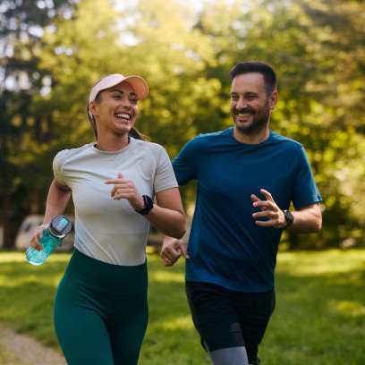 A man and a woman are jogging in a park.
