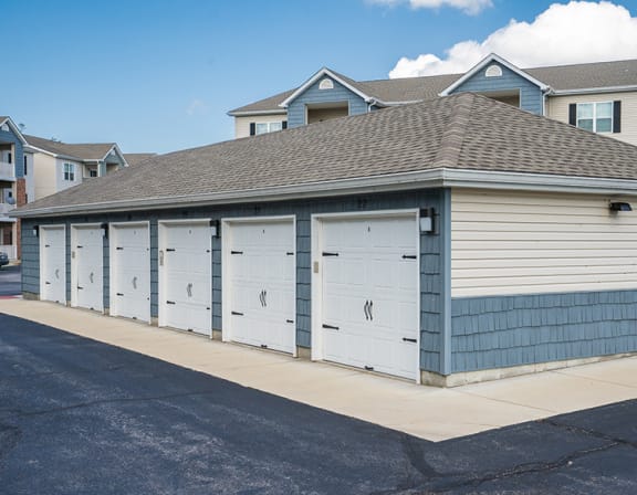 a small garage with four doors on the side of a street