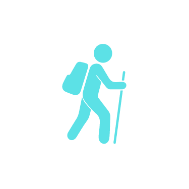 a man walking with a backpack on his back and holding a stick