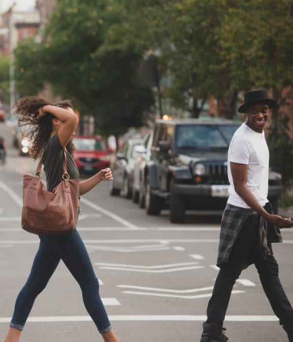 Couple exchanging a laugh while crossing the street