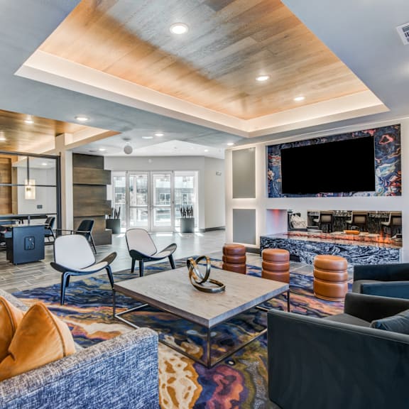A modern living room with a wooden ceiling and a large flat screen TV mounted on the wall.