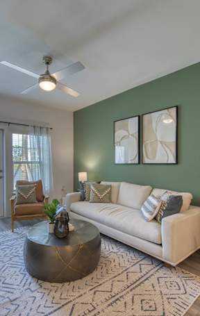 A living room with a couch, a table, and a painting on the wall.