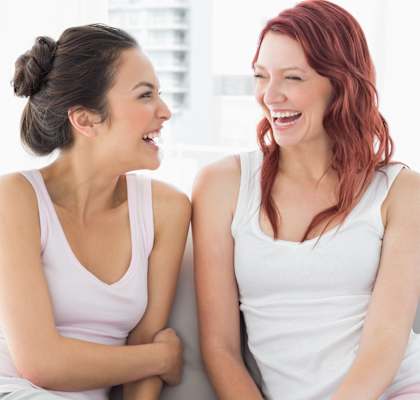 Two friends on couch laughing
