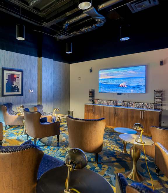 A room with blue chairs and a screen on the wall.