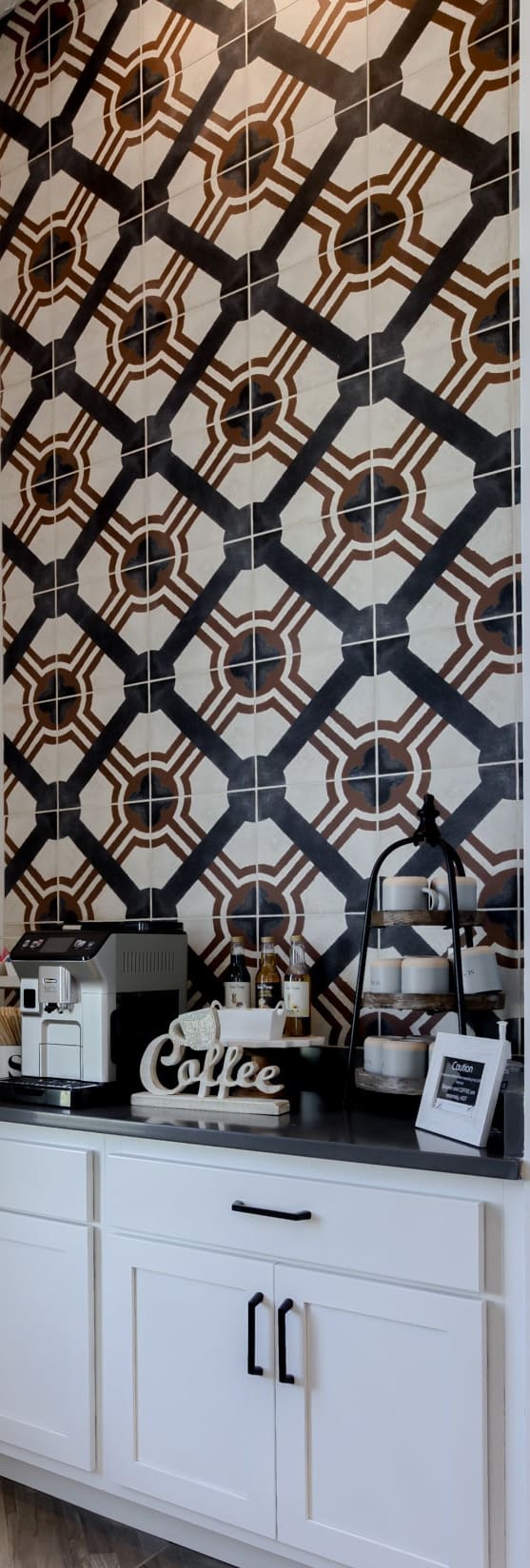 a coffeemaker on a counter in a kitchen with a geometric wallpaper in the background