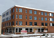 Thumbnail 5 of 16 - A large brown building with a sign that says