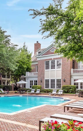 a swimming pool with tables and chairs around it