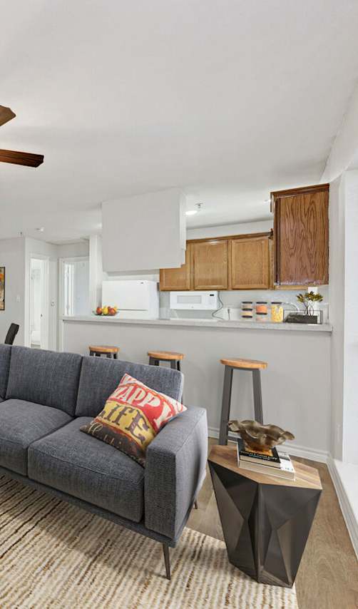 A living room with a grey couch and a wooden coffee table.