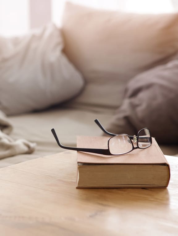 a book and glasses on a table in a living room
