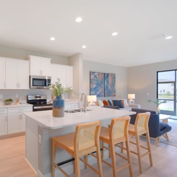 a kitchen with a large island with chairs and a refrigerator at Fiore Townhomes, Venice, FL, 34275