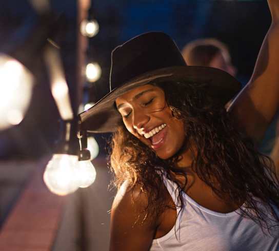 a woman wearing a hat and dancing at a partyat First Street Lofts in Downtown Bismarck, Bismarck, ND