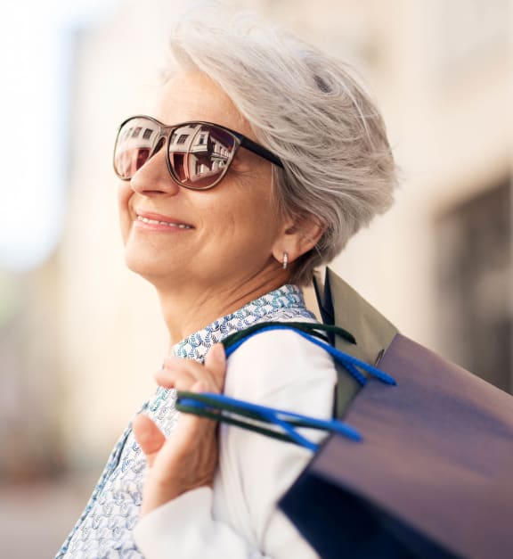 an older woman wearing sunglasses and carrying a backpack  at Pinnacle Apartments, Jacksonville, FL, 32256