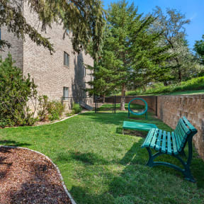 our apartments have a small yard with a bench and a tree