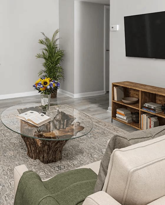 A living room with a couch, coffee table, and a flat screen TV.