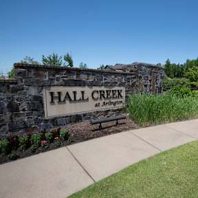 A sign that says Hall Creek at Arlington is on a stone wall. at Hall Creek Apartment Homes, Arlington, Tennessee