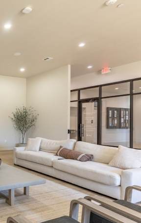A modern living room with a white couch, tv, and fireplace at Northplace Apartment Homes, Salem