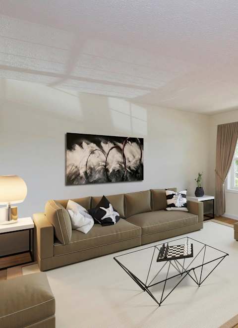 A living room with a brown couch, a coffee table, and a painting on the wall.