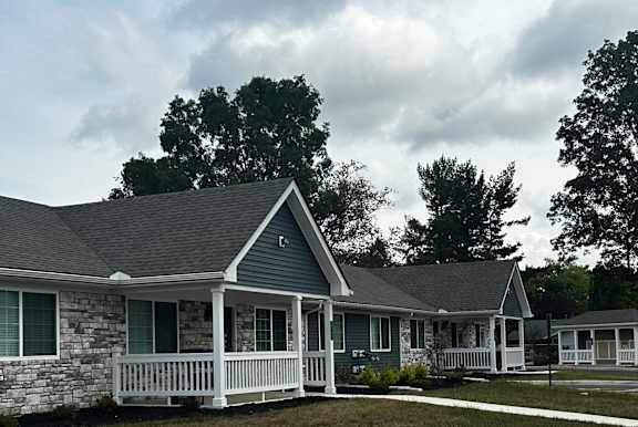 a white and gray house with a porch and a lawn