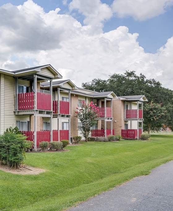 A row of apartment buildings with a red and white building in the front.