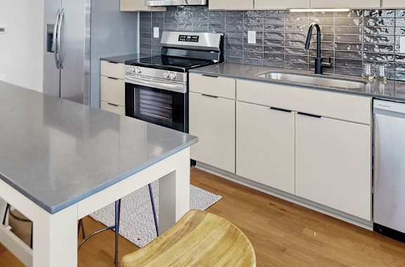 A modern kitchen with a stainless steel island and wooden floors.