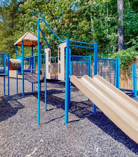 A playground with a yellow slide and blue railings.