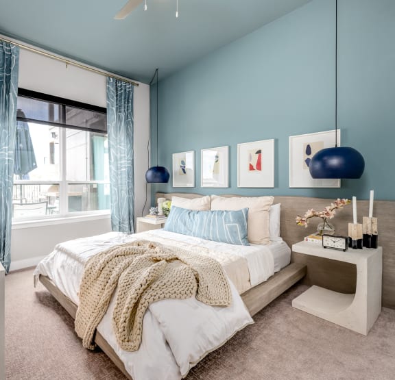 a bedroom with blue walls and a bed and a window at Ironwood Flats in Brandon, Florida 33511