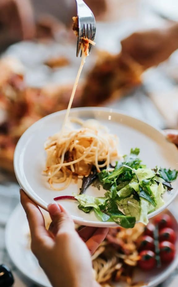 a group of people sitting around a table eating food with