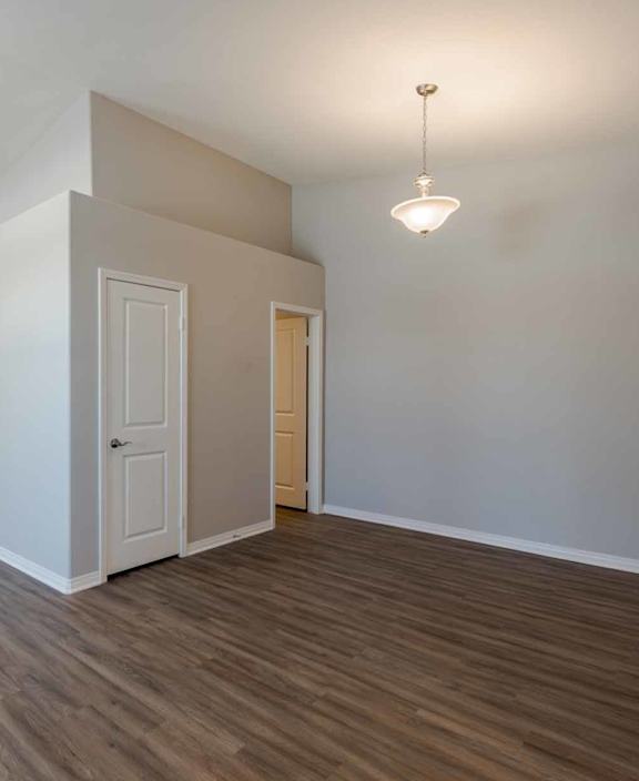 A spacious room with wooden flooring and a ceiling fan.