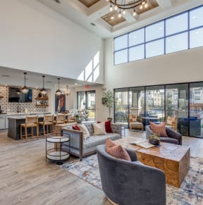 a spacious living room with couches and chairs and a kitchen with a large window