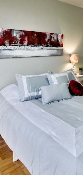 a bedroom with a white bed and a red blanket
