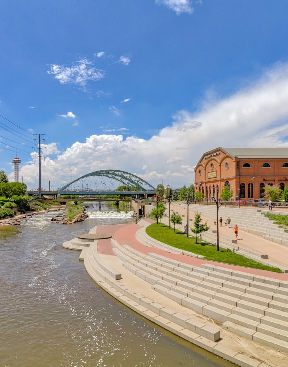 a river running through a city with a building and bridge in the background