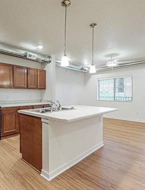 A kitchen with wooden cabinets and a white island at Melbourne Apartments, Georgia