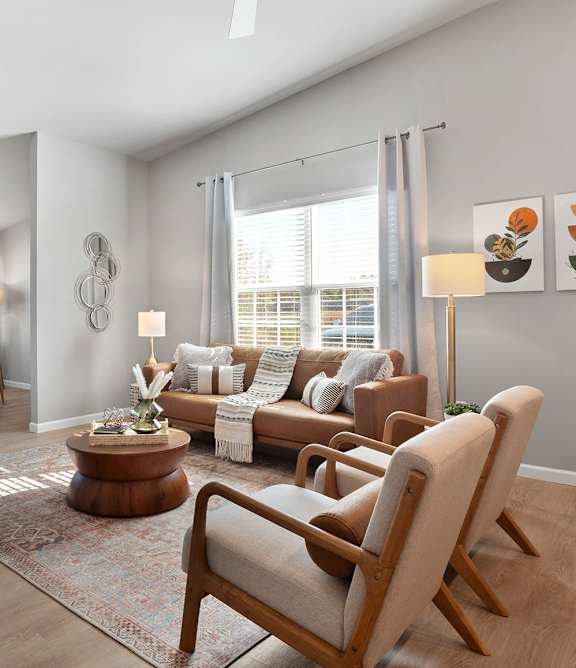 A modern living room with a brown leather couch and a television.