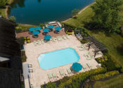 Thumbnail 17 of 25 - Sundeck and resort-style pool with lounge chairs, umbrellas, patio tables, and BBQ area at The Coleman in Canal Winchester