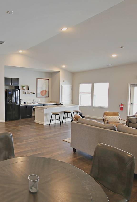A modern living room with a dining table and chairs.