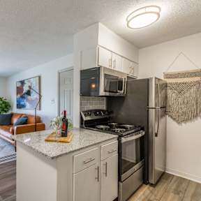 a kitchen with granite counter tops and a stainless steel refrigerator at Brightwaters Apartments, Little Rock, Arkansas
