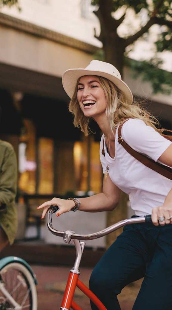 Two people riding bicycles in an urban setting.