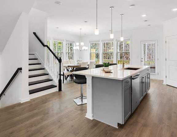 a living room with a kitchen and a staircase