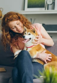 a woman sitting on a couch with her dog at Mountain Breeze Apts, Pomona, CA