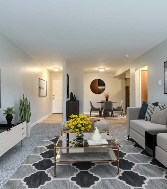 A modern living room with a grey couch, a coffee table, and a flat-screen TV on the wall.